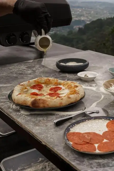 Menikmati pizza di meja marmer